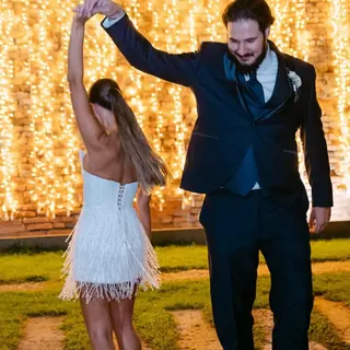 Sposa che balla con lo sposo nel secondo abito con frange